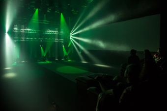 green concert lighting with a small crowd to the right
