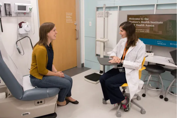 a doctor and patient talk in an examination room at the design institute for health