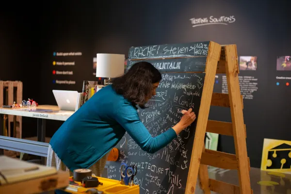 student interacting with MFA Design student's exhibition at UT Austin's School of Design and Creative Technologies