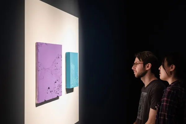 Two people exploring a student exhibition on display at the Visual Arts Center