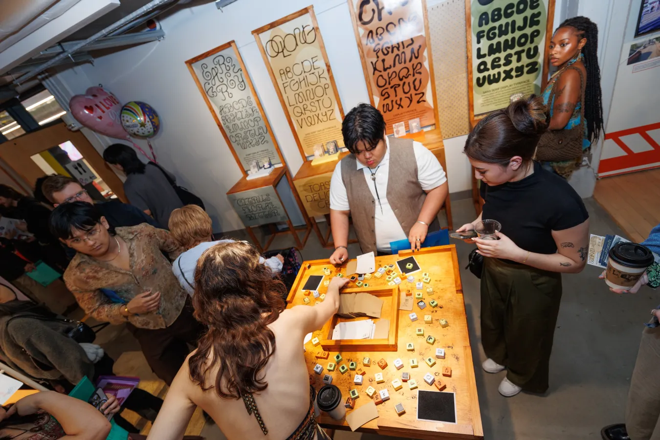 Attendees of Then&Now&Tomorrow interacting with a project on a large square table