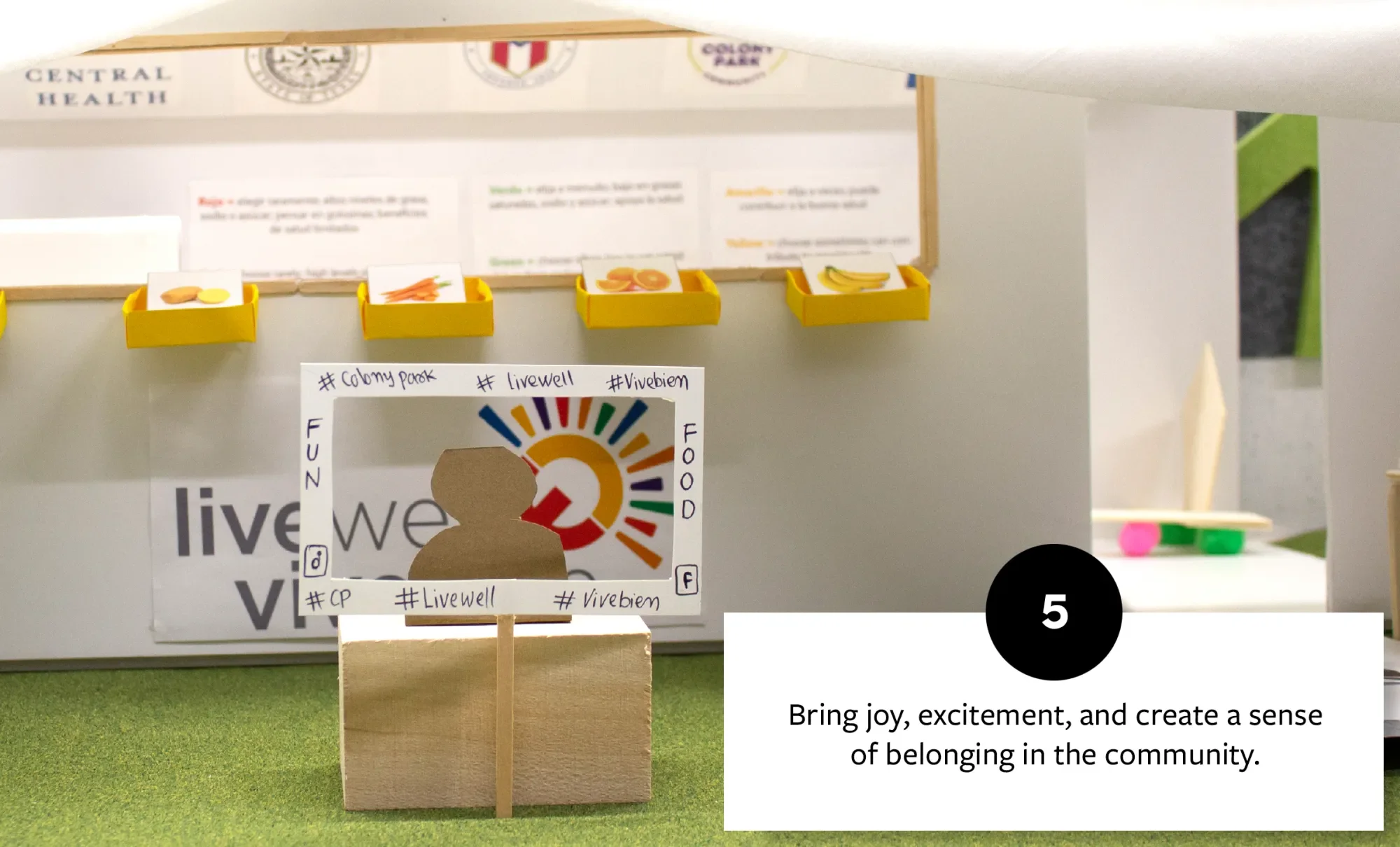 Interactive display with a cardboard figure and a cut-out photo frame, promoting a sense of community and engagement with joyful elements like colorful food images.