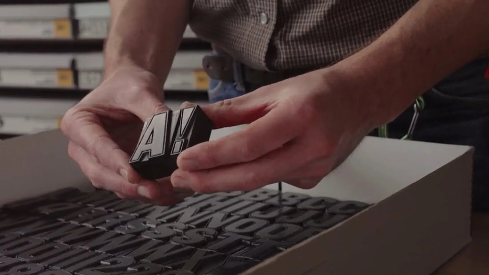 Close-up on hands holding vintage type blocks from the Rob Roy Kelly Type Collection