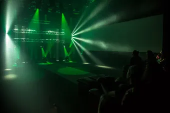 green concert lighting with a small crowd to the right