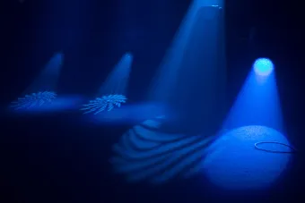 blue spotlights create snowflake like patterns on the ground