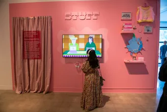 A Becauseisms attendee interacting with Stuff installation by listening through headphones