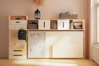 A murphy bed unit with shelves and a closet, in a clean, modular design, folded with a desk visible.