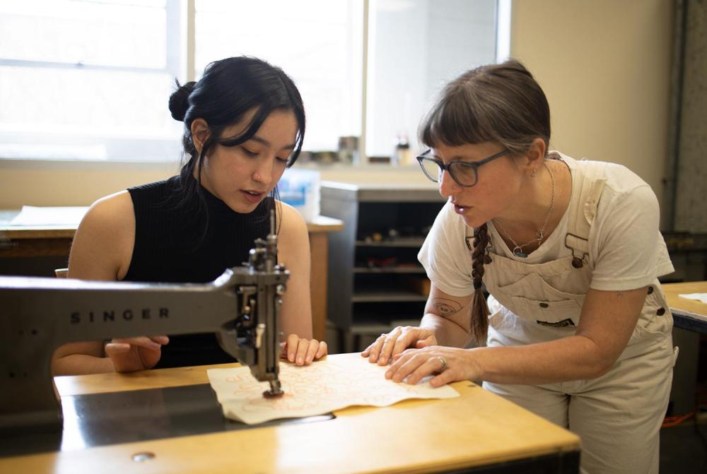 Kathie Sever teaches Design junior Hue Minh Cao how to chain stitch during the workshop.