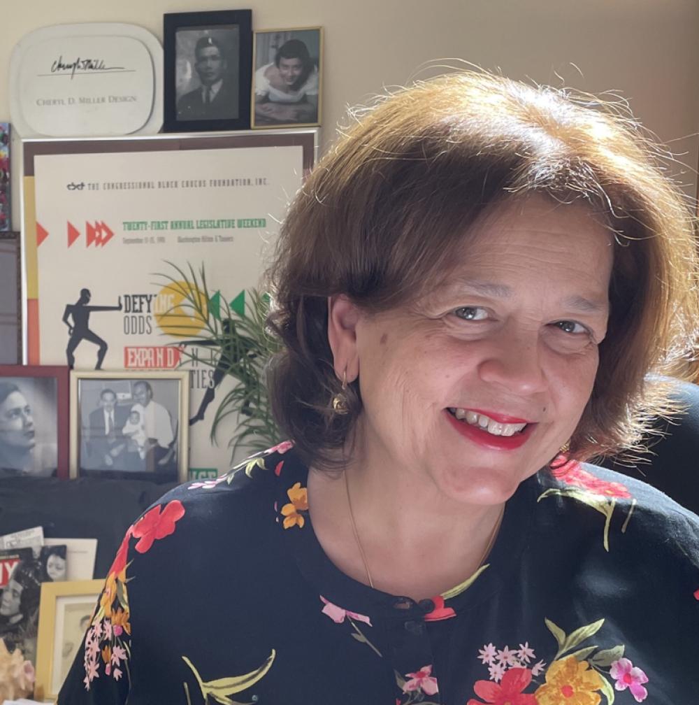 Cheryl Miller smiling in front of awards in her office