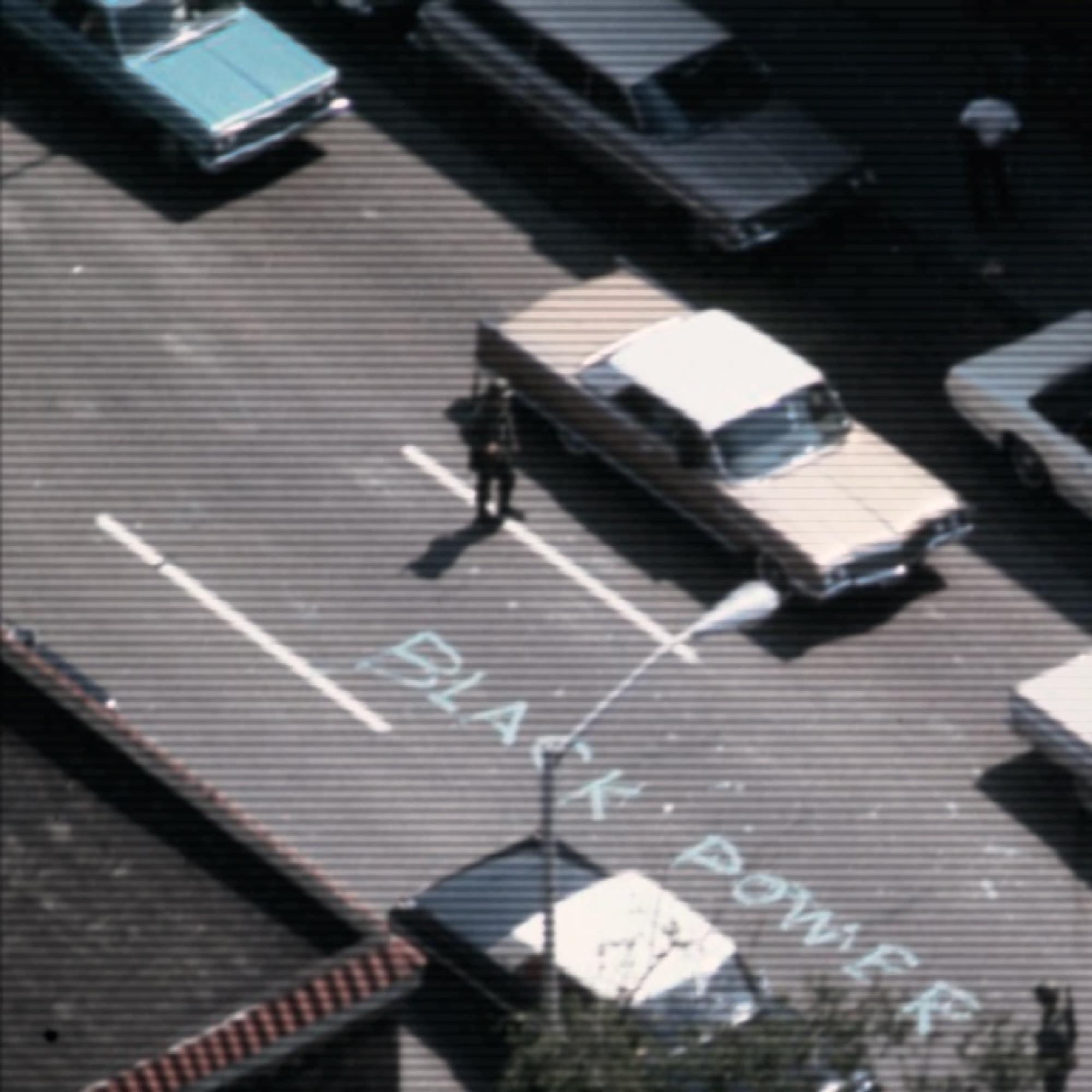 Source: Detroit, July 1967. Lee Balterman/Life Pictures/Getty Images 1967 color photo of cars on a highway. a man stands in the middle of the street next to the words Black Power written in chalk