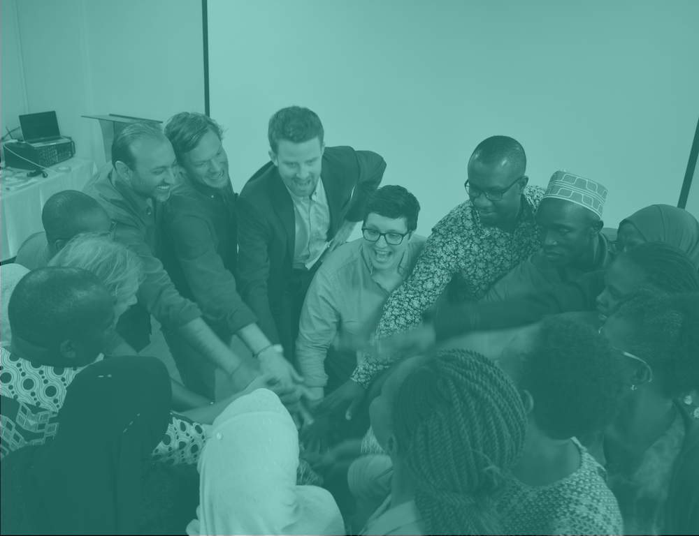 A team huddle at the Nairobi, Kenya Train the Trainer training. Katie Krummeck is pictured in the center, Dr. Andrew Cunningham is to her left, Gray Garmon is to his left, and Munir Ahmad is to his left.