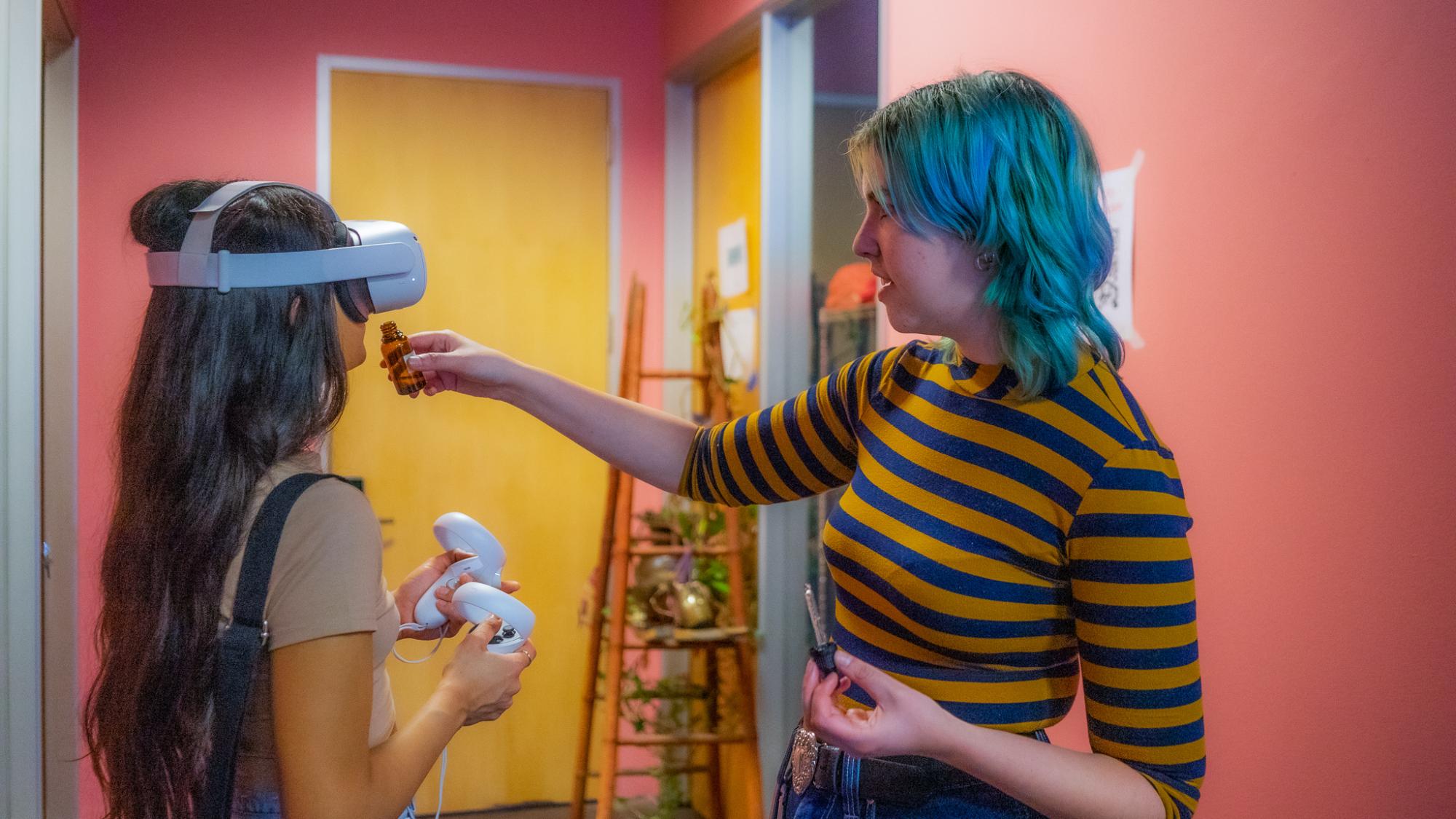 School of Information student Amanda Miller guiding exhibition attendee through their What Your Dog Might See virtual reality project