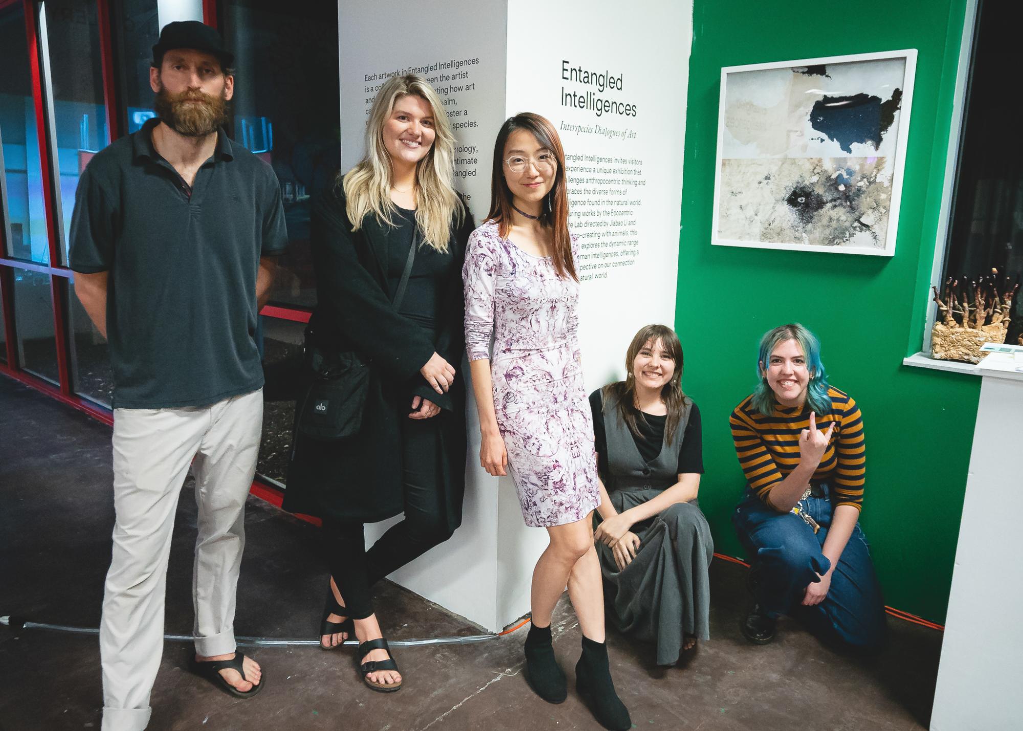 The team behind Entangled Intelligences posing in front of the exhibition entrance