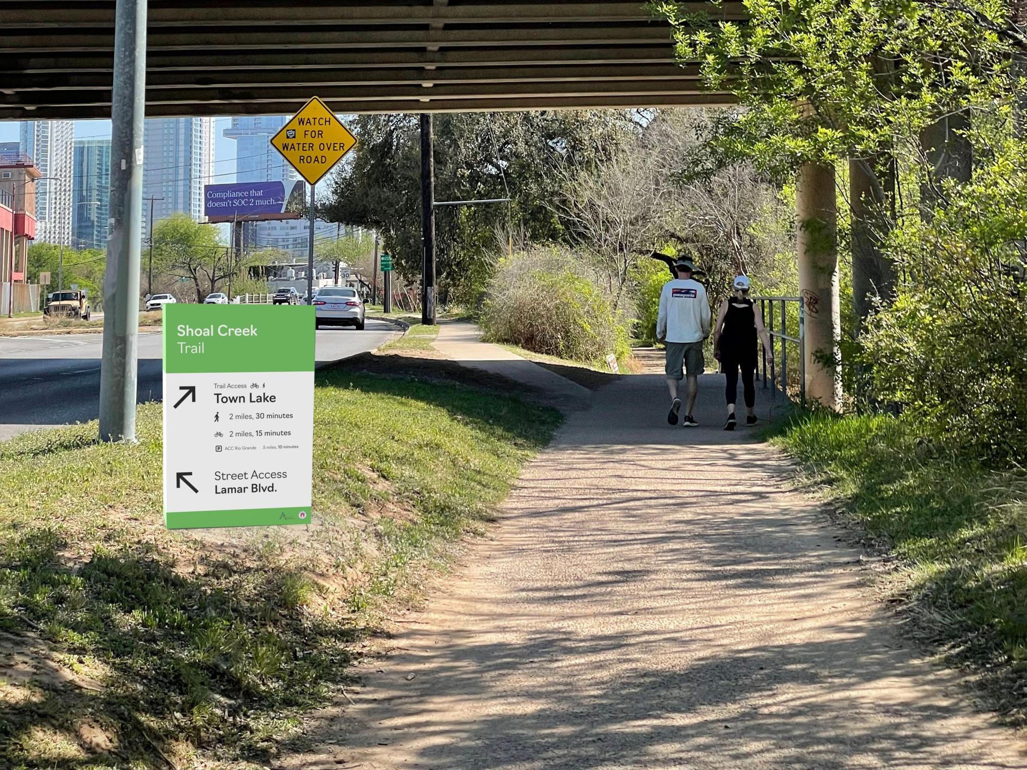 Park trail with couple walking in the background and a trail sign mockup in the foreground