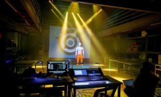 still of light show presentation from professor Matt Smith's live event engineering class. a mannequin stands in the middle of the PLAI lab while the light show happens around you
