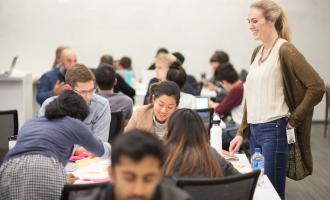 Students working on a project with a supervisor from IBM during an off-site course offered as part of the Bridging Disciplines Program in Design Strategies