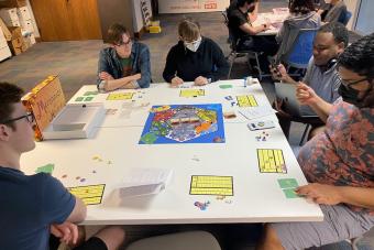 Students in Tyler Coleman's AET Physical Games course playing their original board game "Merchants of Hexaria"