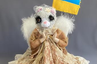 image of Yuliya Lanina handmade sculpture of a squirrel-like animal in a dress holding the Ukrainian flag