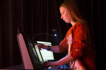 a woman at a theatrical lighting programming board