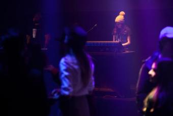 student wearing a winter hat and running a lighting board