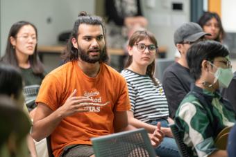 Student in burnt orange UT shirt asking a question during George Aye's Fall 2022 lecture for the Center for Integrated Design at SDCT