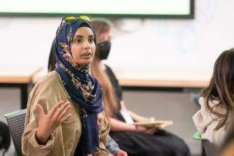 M.F.A. student in hijab asking a question during a Fall 2022 public lecture with designer George Aye