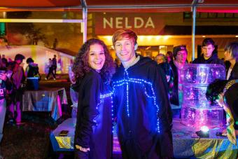 AET students in light-up costumes during Ride the Synthwave event in 2022, sponsored by Nelda Studios