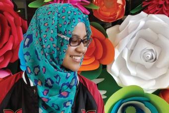 GDUSA Student to Watch wearing a hijab in front of a floral background