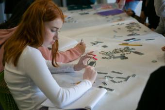 High school student learning about typography using metal objects during 2020 Graphic Design Summer Camp at UT Austin