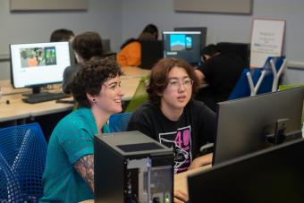 Summer Camp Director Jessie Contour helping a high school student work on their original video game