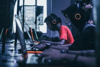 People playing video games on their laptops with headphones on. Photo by Fredrick Tendong from Unsplash