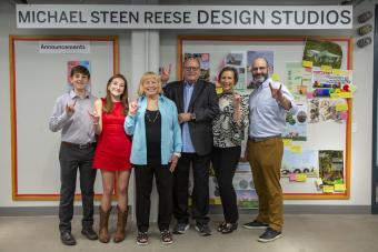 Mike Reese and family posing in front of new sign for the Michael Steen Reese Design Studios in Anna Hiss Gymnasium