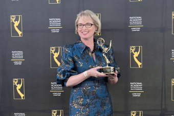 AET lecturer Natasha Davison holding her Lone Star EMMY Award for producing writing and directing the Muraling Austin series