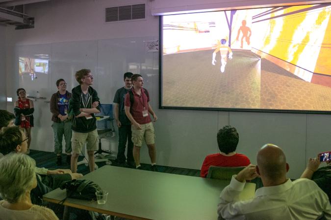 a group of high school students present their original video game to their parents at the 2019 SDCTx Game Design Summer Institute showcase