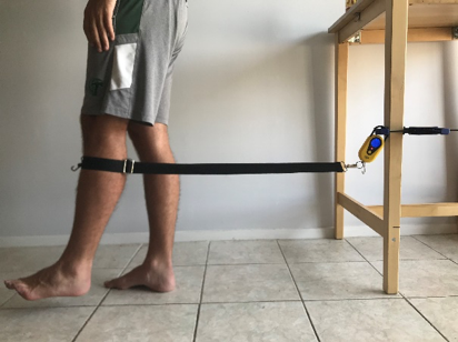 a person tests the MMT prototype on their leg at home by connecting it to a table in their kitchen