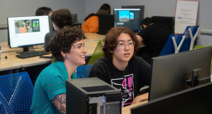 Summer Camp Director Jessie Contour helping a high school student work on their original video game