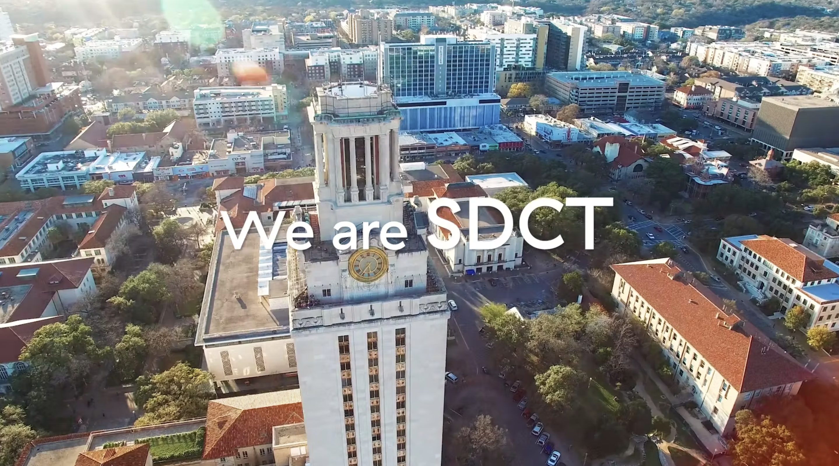 The words We are SDCT overlaid against a drone shot of the UT Tower